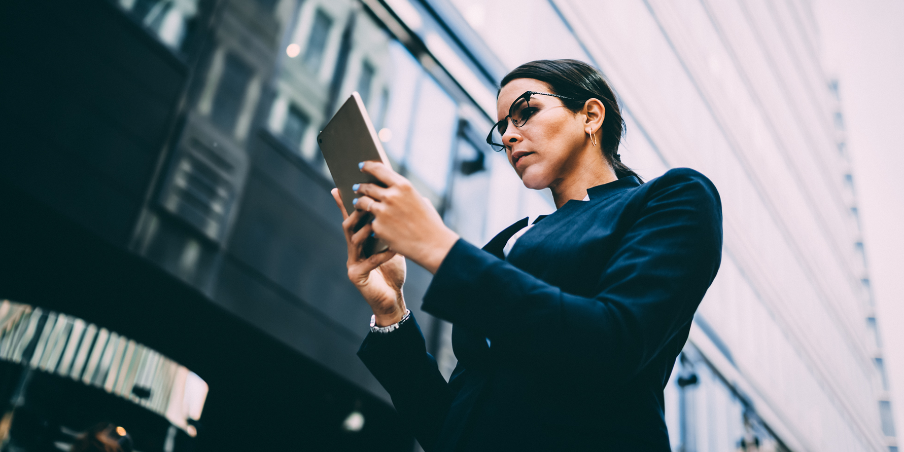 Photograph of a revenue operations leader looking at a report on a tablet on a city street