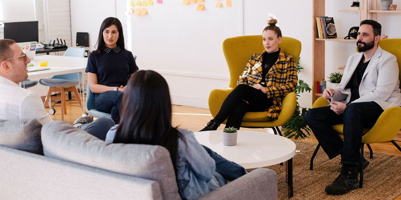 Photograph of a group of sellers discussing deals in a sales meeting