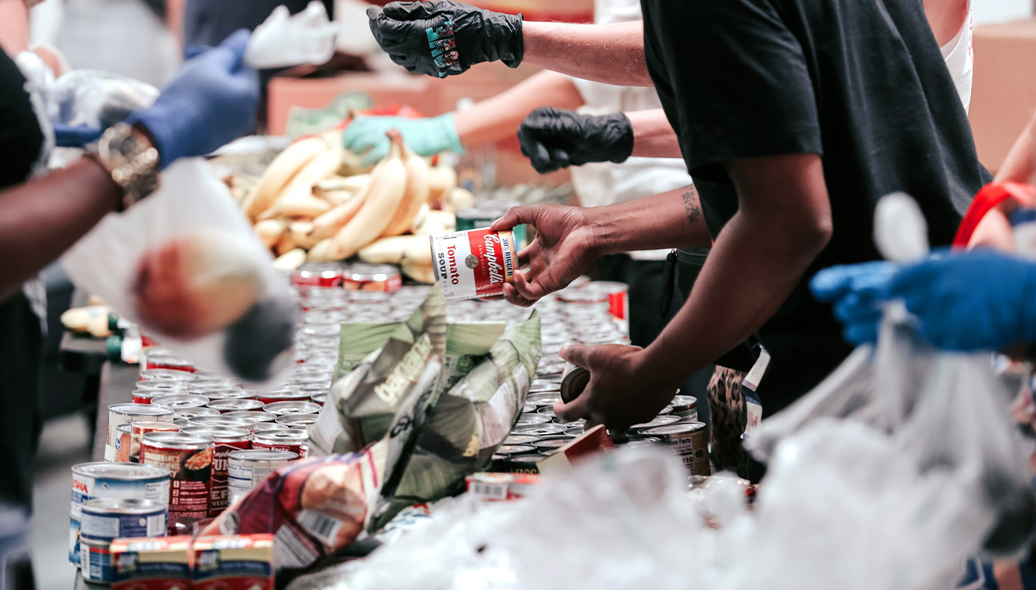 People wearing gloves handing out food