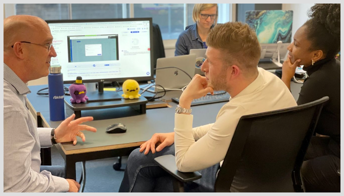 Group of people chatting in front of a computer