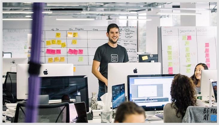 Intercom employee standing and smiling in the office