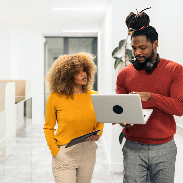 Photograph of two sales engineering professionals looking at a report on a laptop